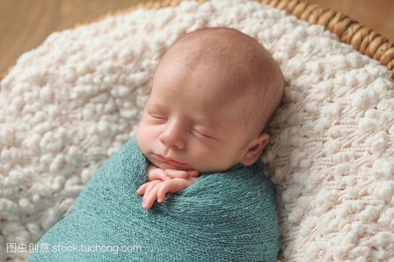 睡在蓝色襁褓的初生男婴