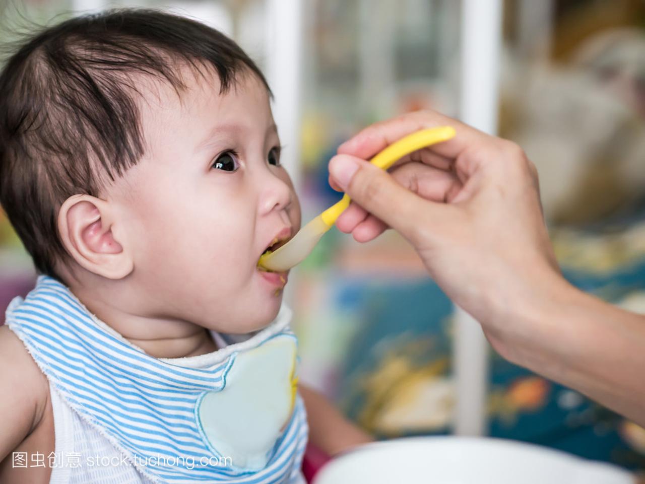 亚洲婴儿 6 个月大吃食物从勺子