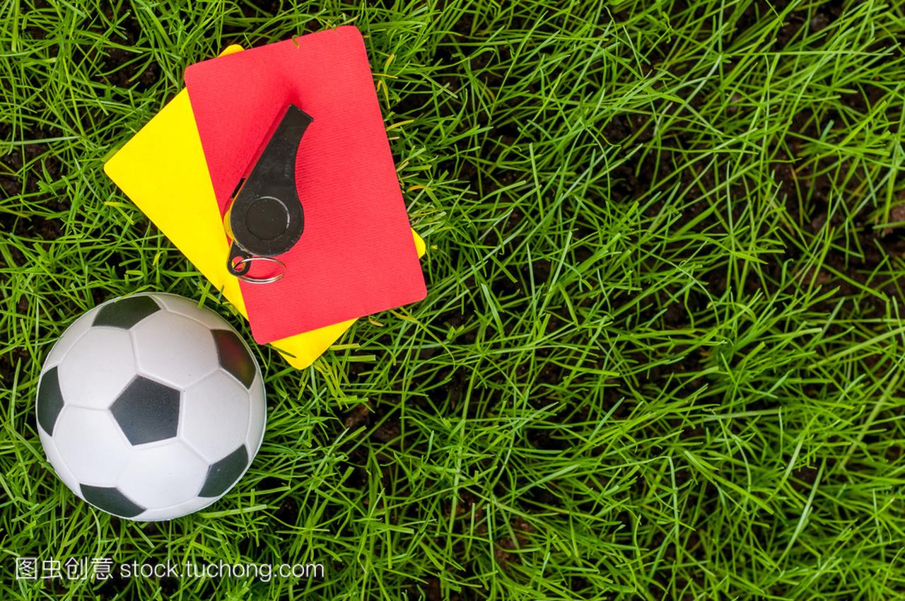 足球裁判装备与球的体育场草坪上的黄色和红色