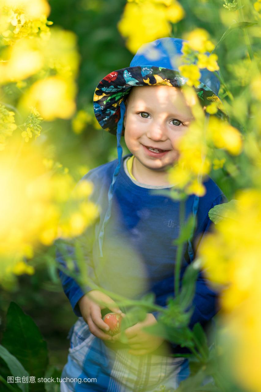 小一岁的男孩在一顶帽子站在黄流中间