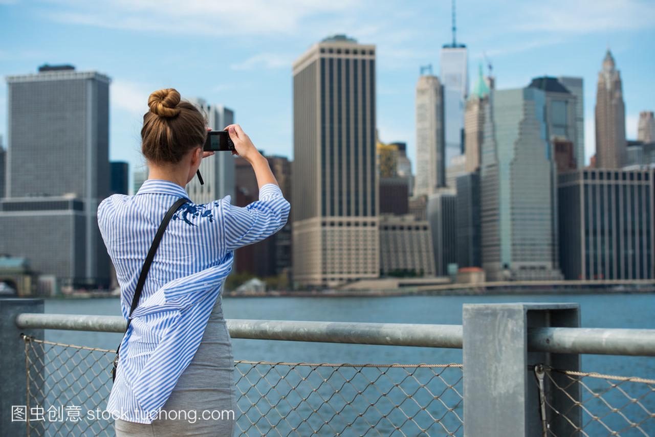 旅游女人拍照旅行用相机的曼哈顿天际线和纽约
