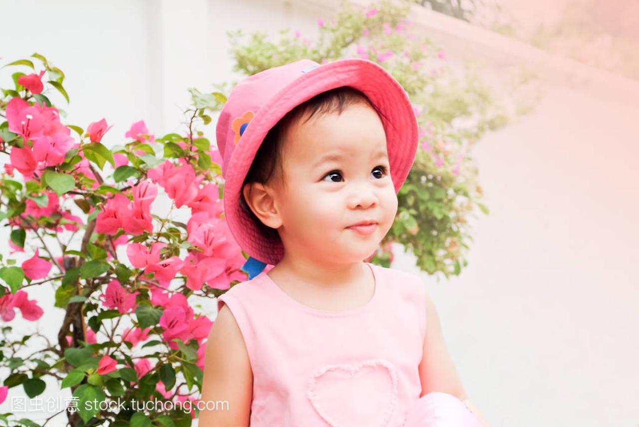 亚洲小女孩粉红色的帽子和衣服
