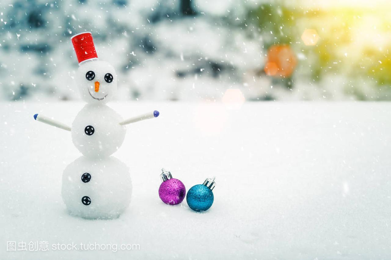 在一次降雪过程中微笑雪人和圣诞装饰品,在森