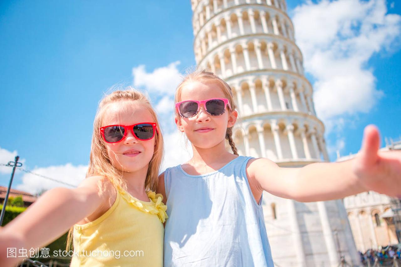 小女孩采取自拍照的游客们的背景在意大利比萨