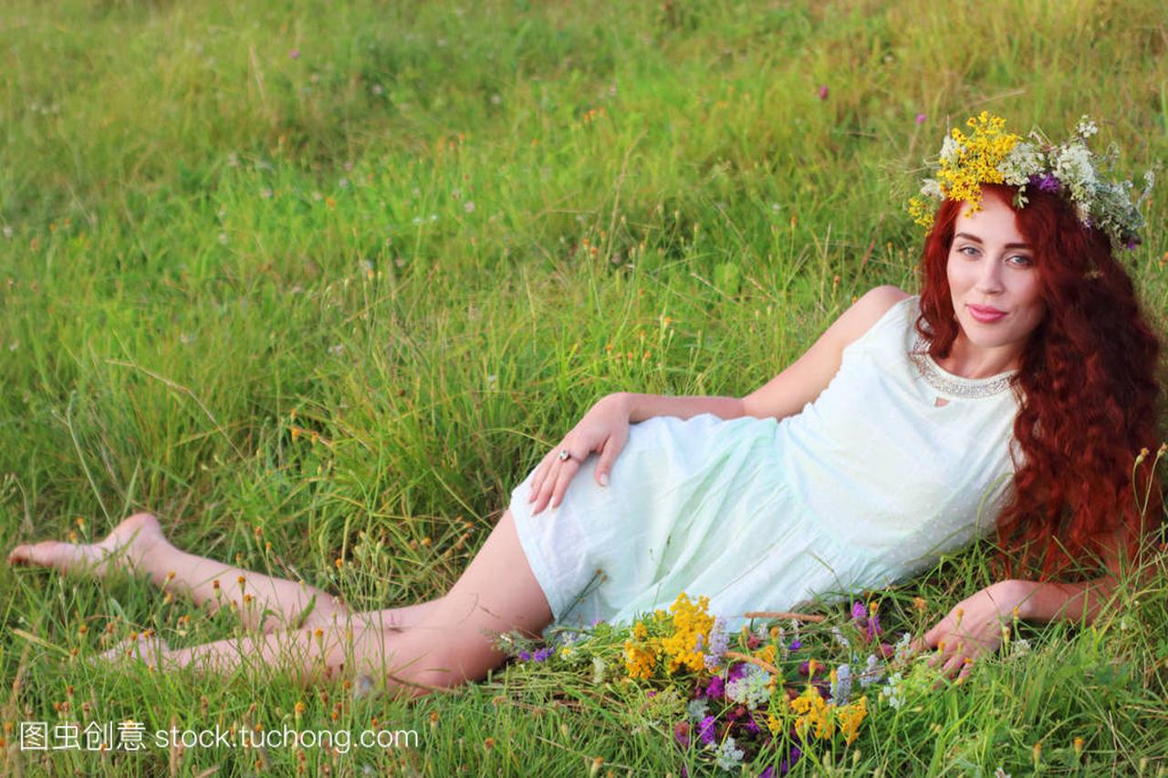 在花圈和短裙赤脚女人躺在草地上的草