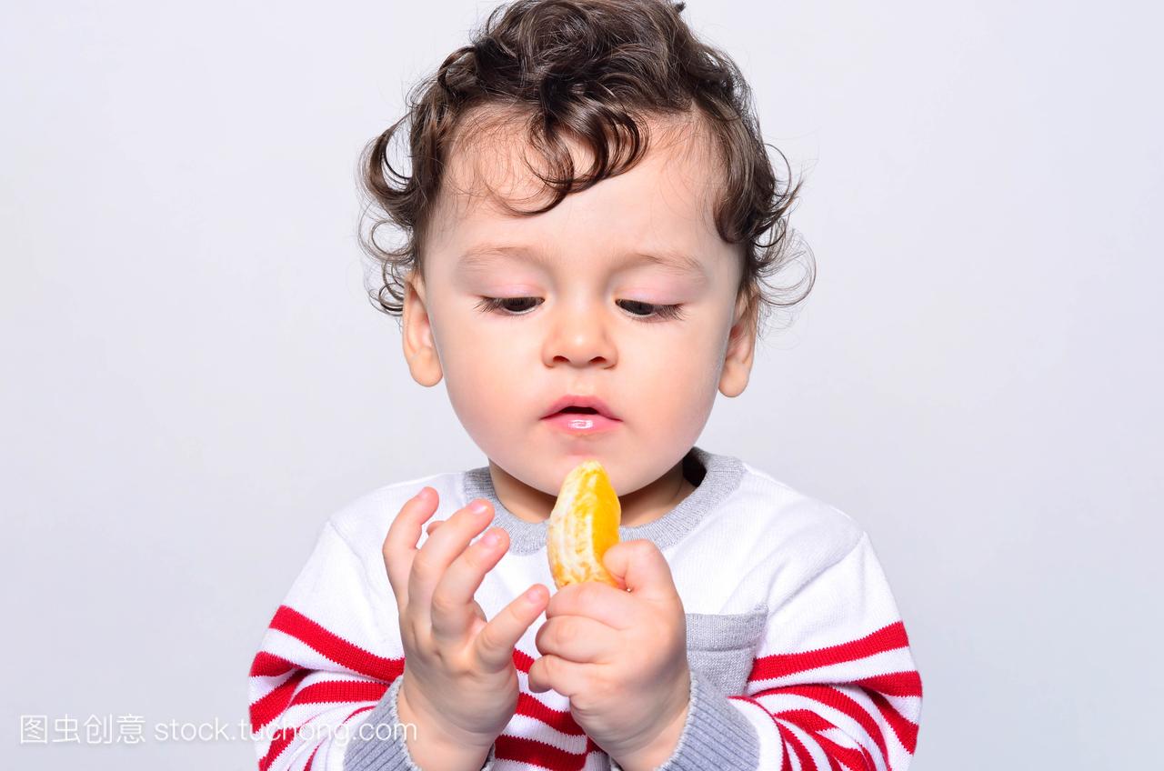 一个可爱的宝宝,吃橙子的肖像
