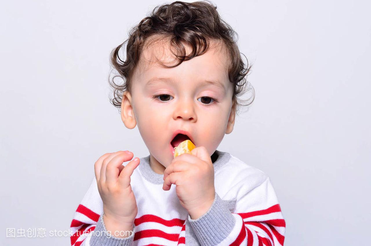 一个可爱的宝宝,吃橙子的肖像