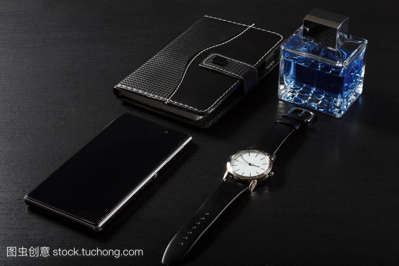手表、 笔记本、 手机,男人在黑色背景上的香水