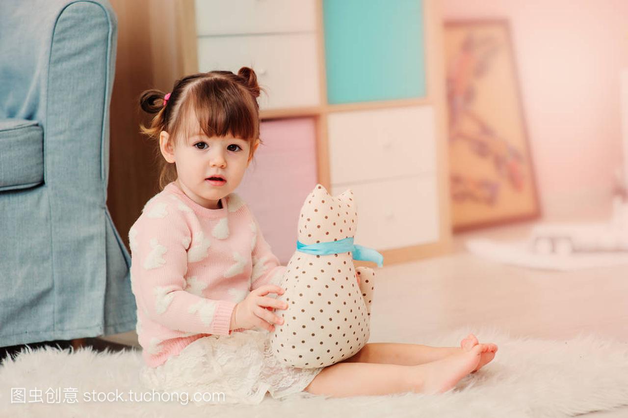 可爱快乐 2 岁小女孩玩玩具在家里。Pastele 音