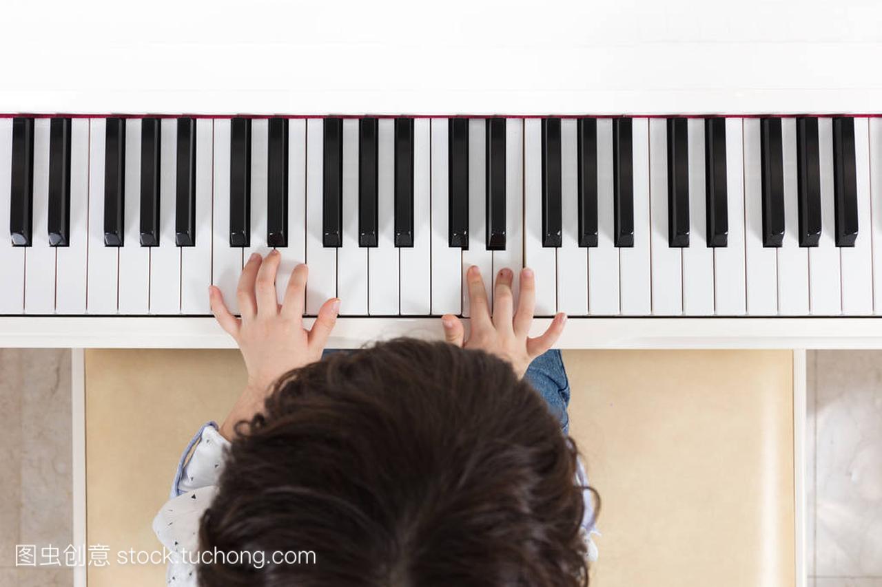 亚洲的中国小男孩弹钢琴的鸟瞰图