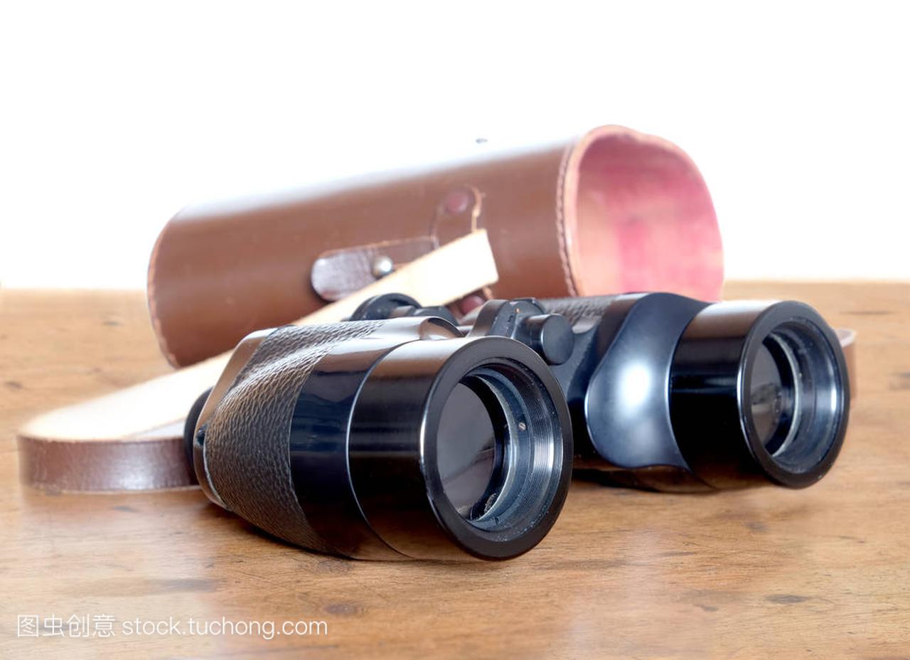 黑色的老式棱镜颜色双筒望远镜和棕色皮套