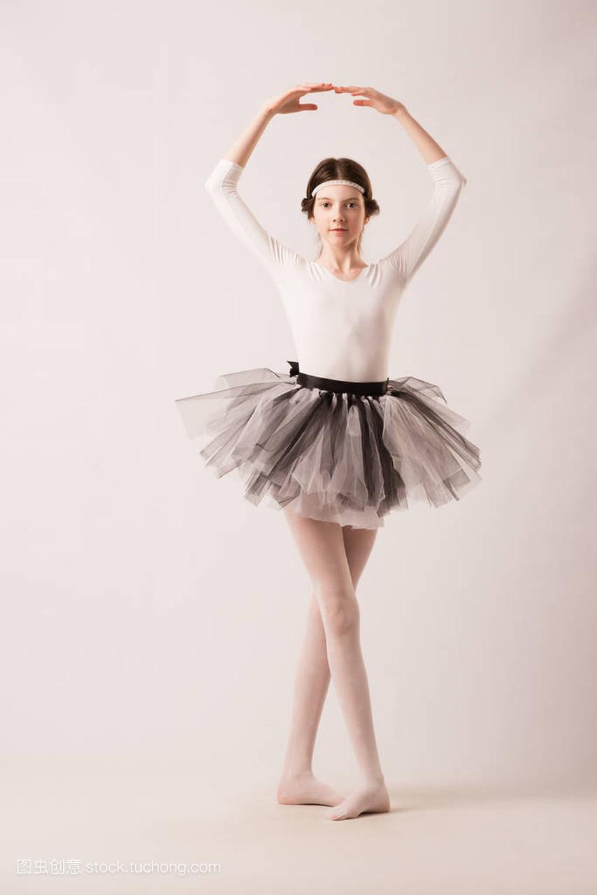 女孩在轻便的服装跳芭蕾舞与白色背景