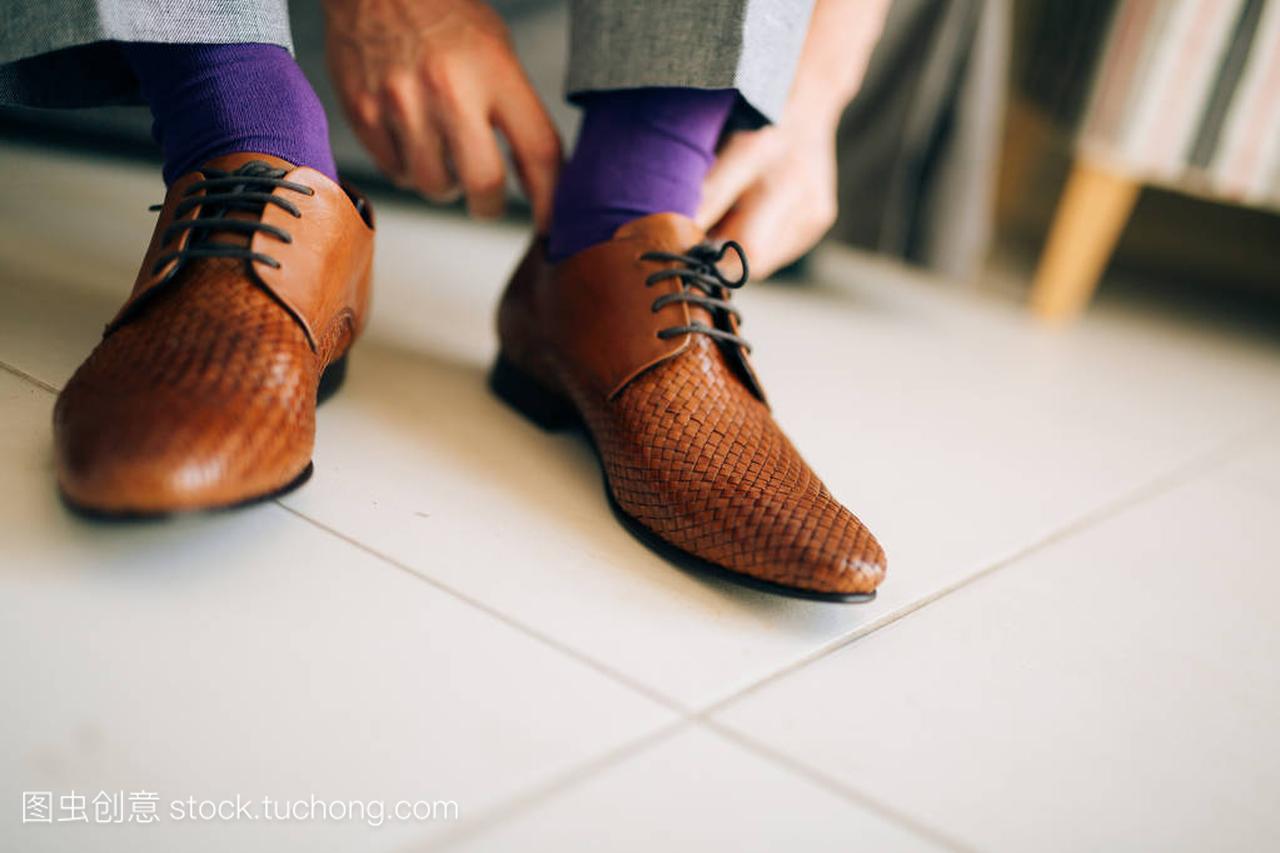 男人在灰色休闲裤和一件紫色的连衣裙袜子棕色