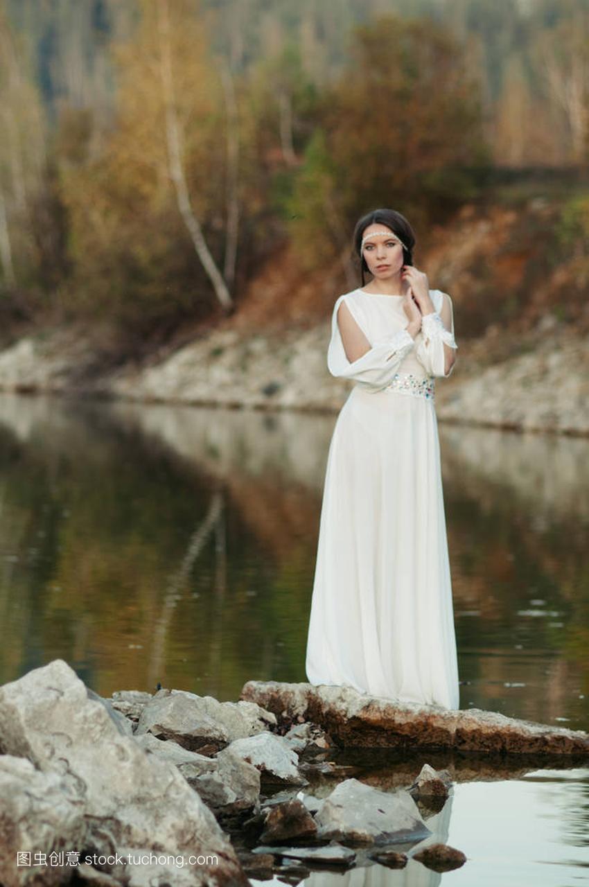 一个池塘,岸上穿白裙子的女孩