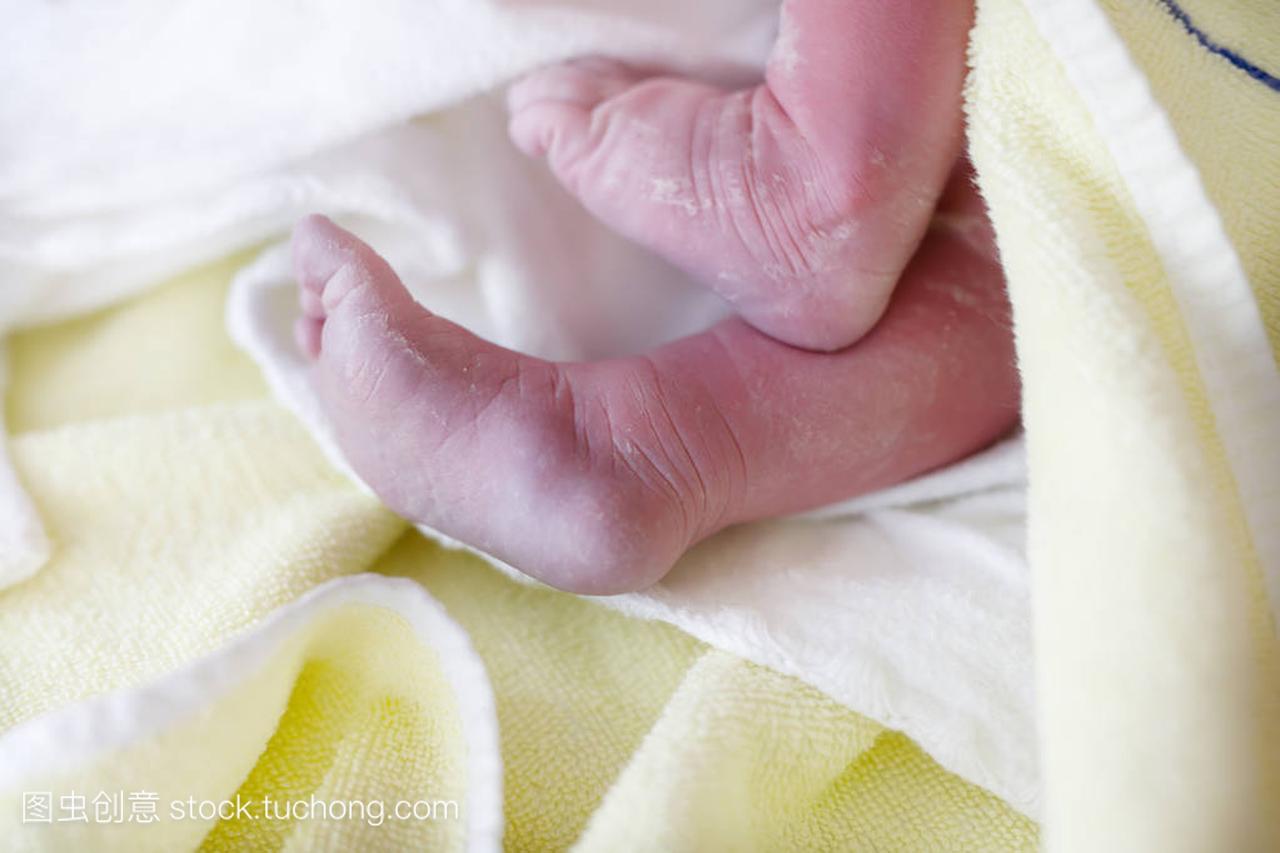 新生儿婴儿儿童秒和分钟后出生躺在毛巾上的脚