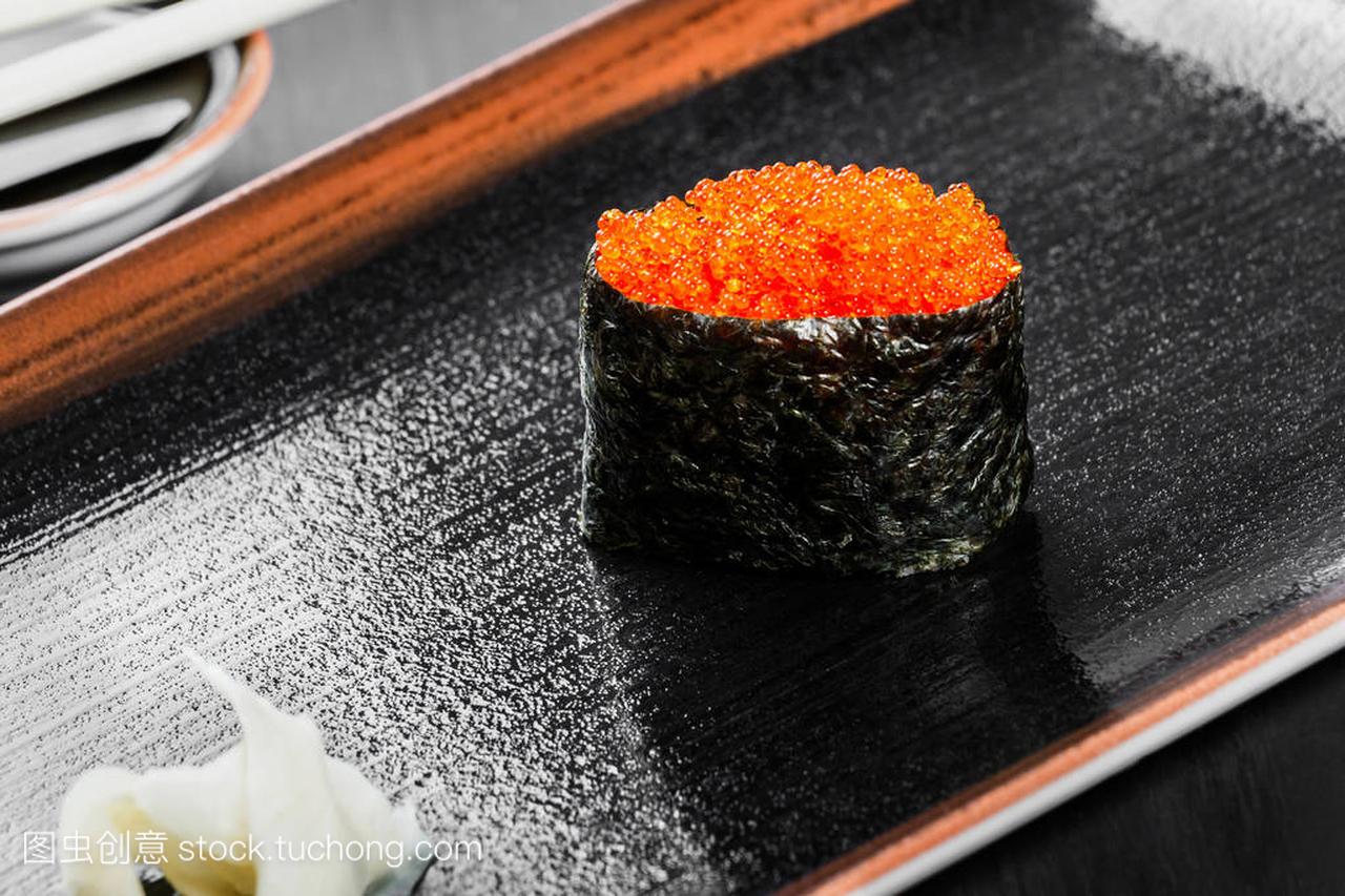 配上深色的木质背景鲑鱼鱼子酱寿司京坎费工。