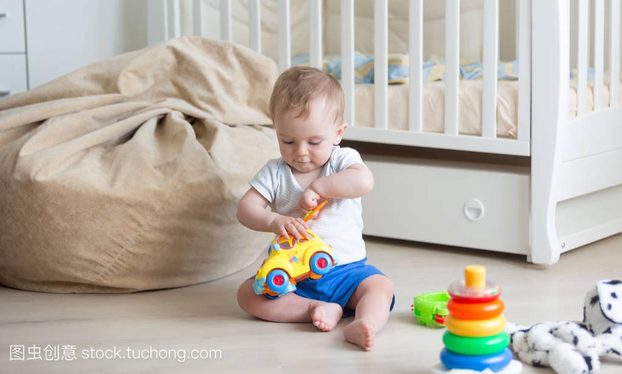 10 个月大婴儿玩具车与块地板上玩