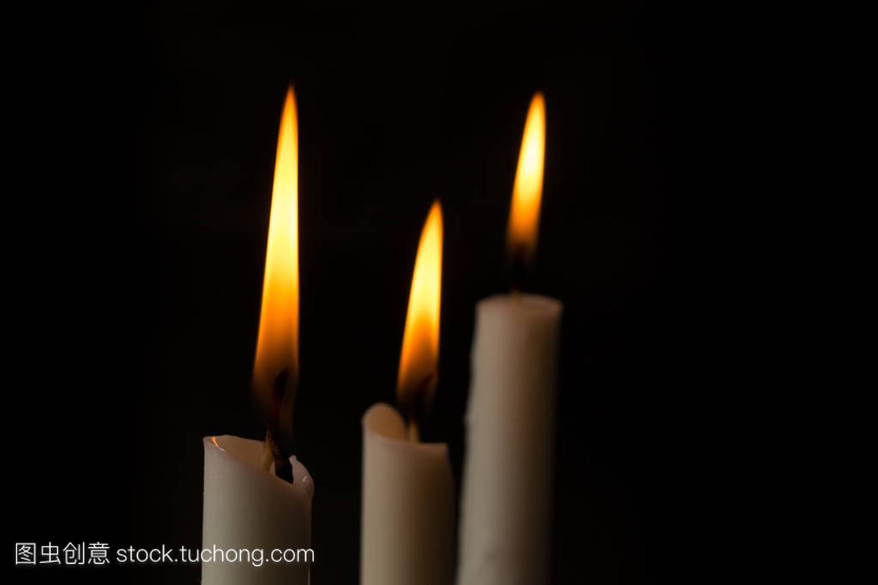 三个蜡烛火焰在黑色背景上