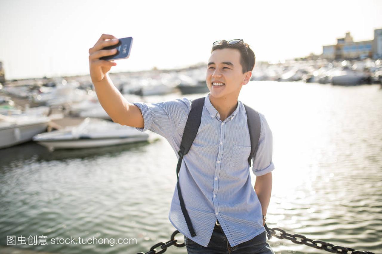 微笑的亚洲人以自拍照附近 th 海船的肖像