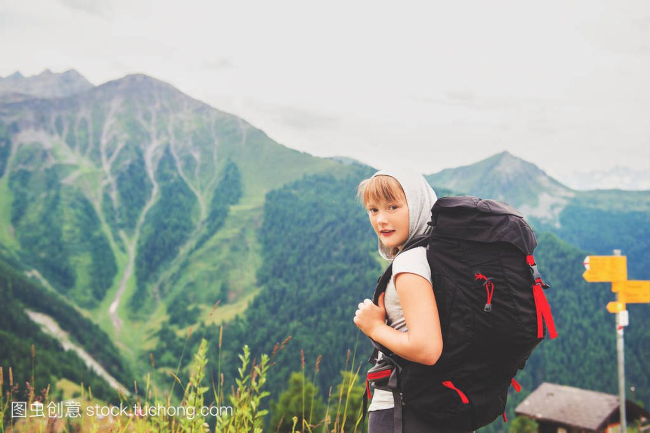 快乐的小女孩,徒步旅行在瑞士阿尔卑斯山,穿着