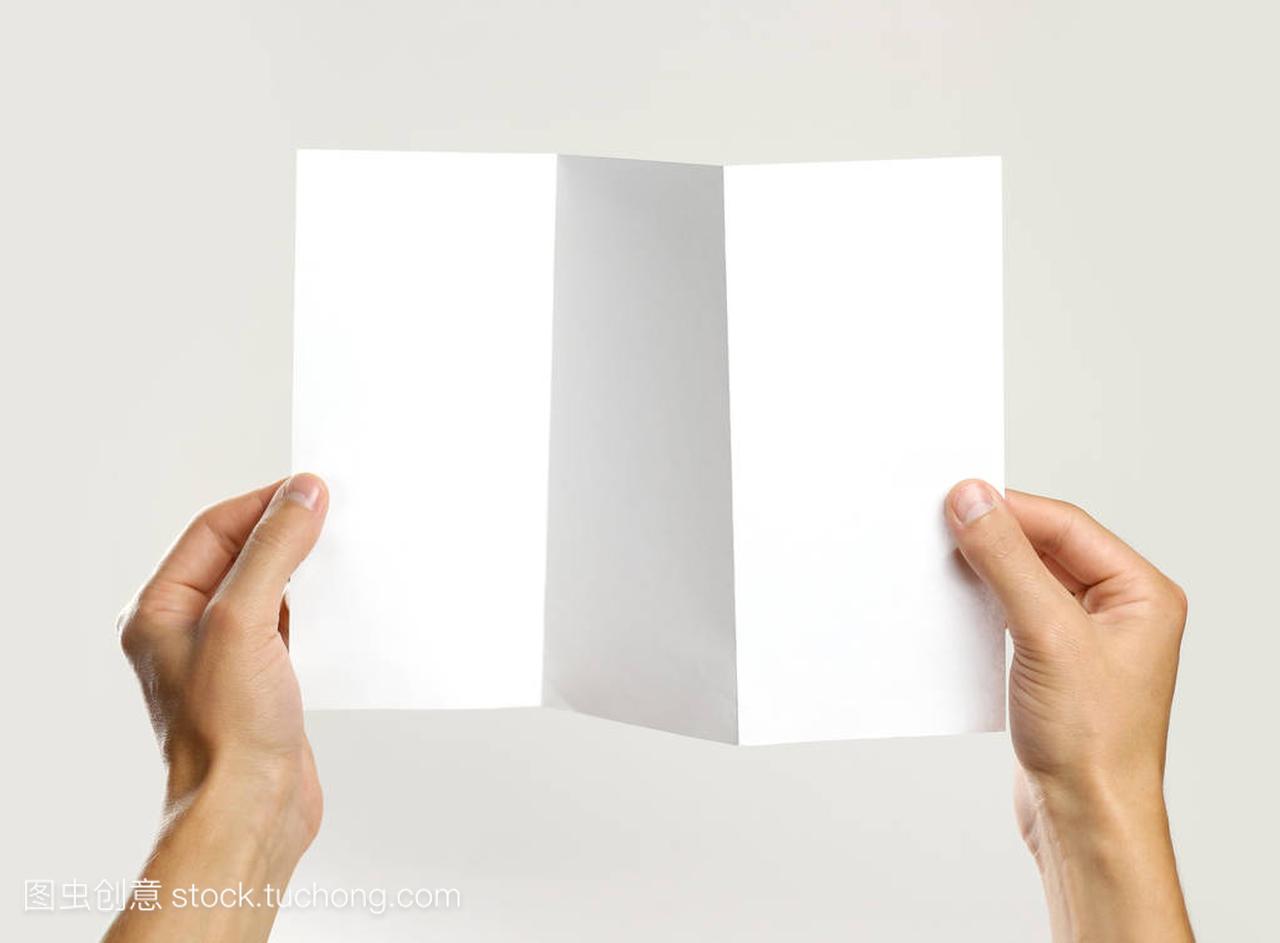 男手里拿着一本小册子,白色的三张纸。