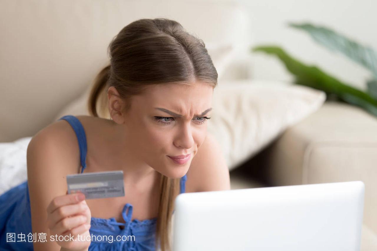 困惑的妇女有问题与信用卡做网上支付