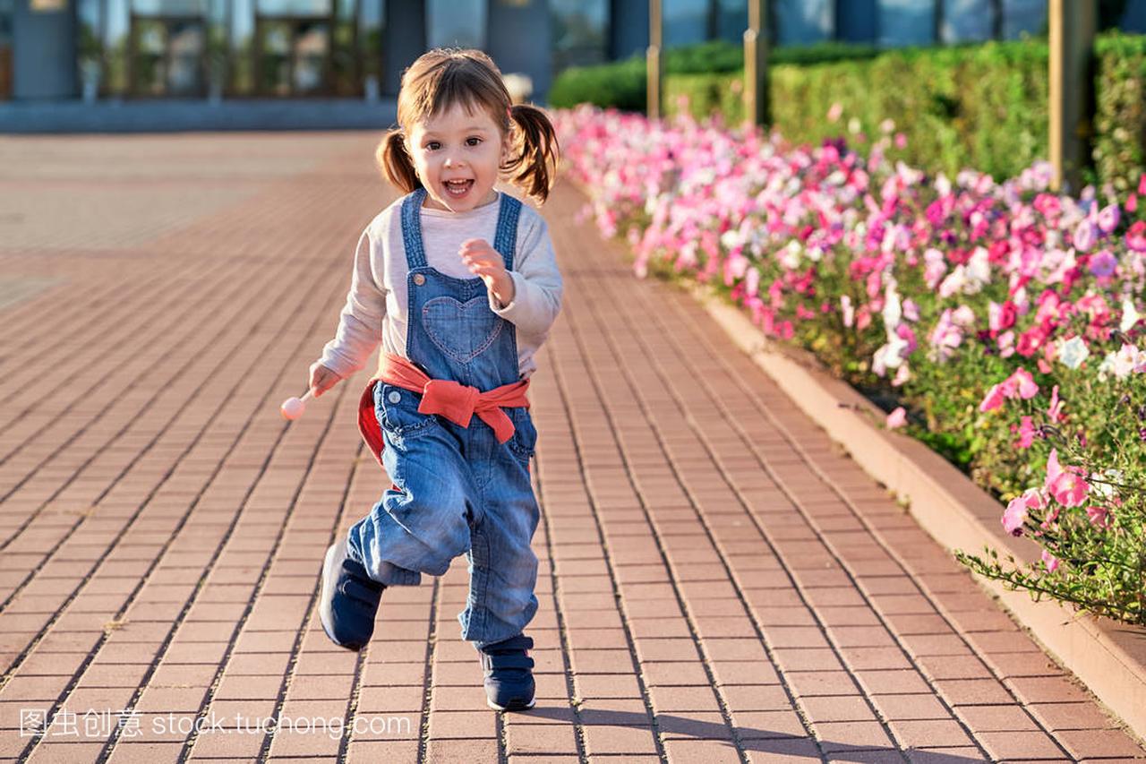 有趣的小女孩跳 joy.little 女孩在牛仔连身裤