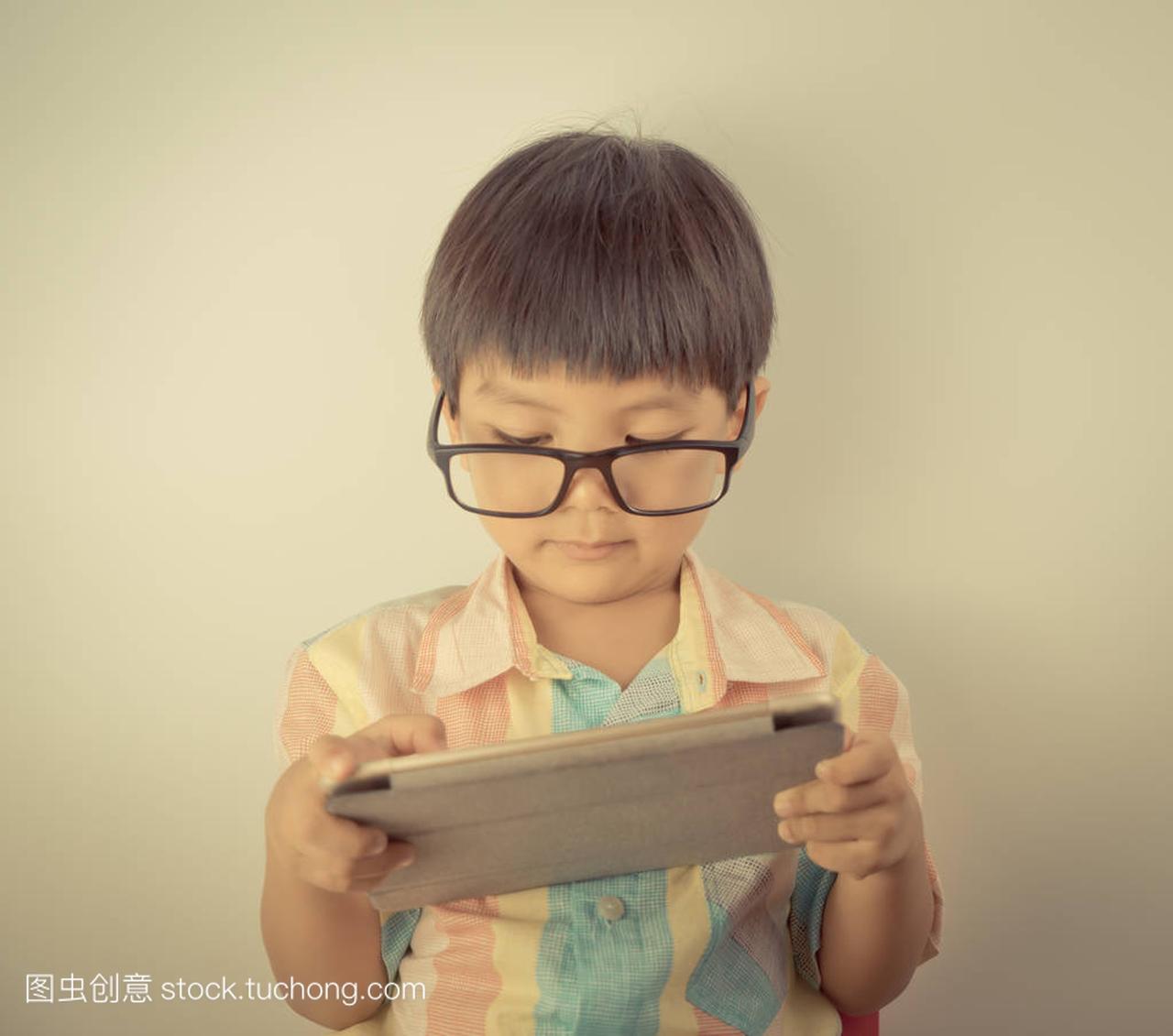 与眼镜的书呆子男孩使用一台平板电脑
