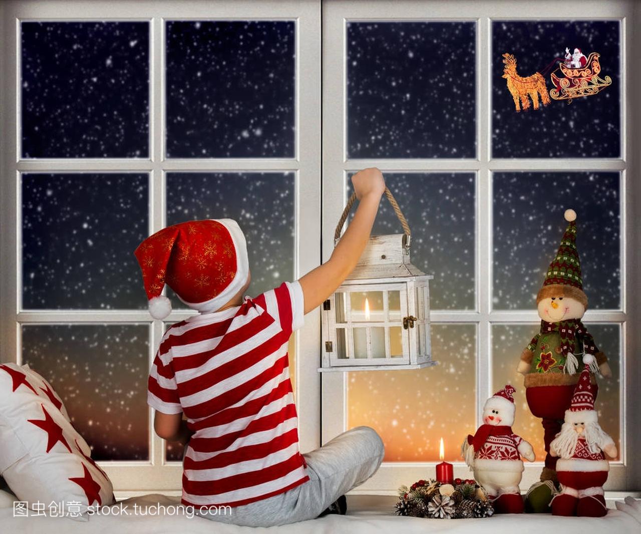 圣诞快乐, 节日愉快!小男孩坐在窗前, 看着圣诞