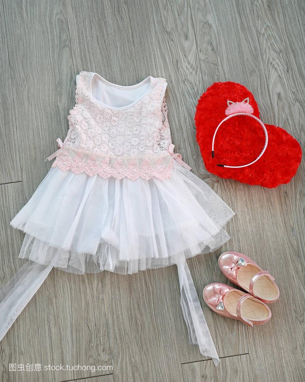 粉红色的白色蕾丝连衣裙与女孩的小鞋子和红色