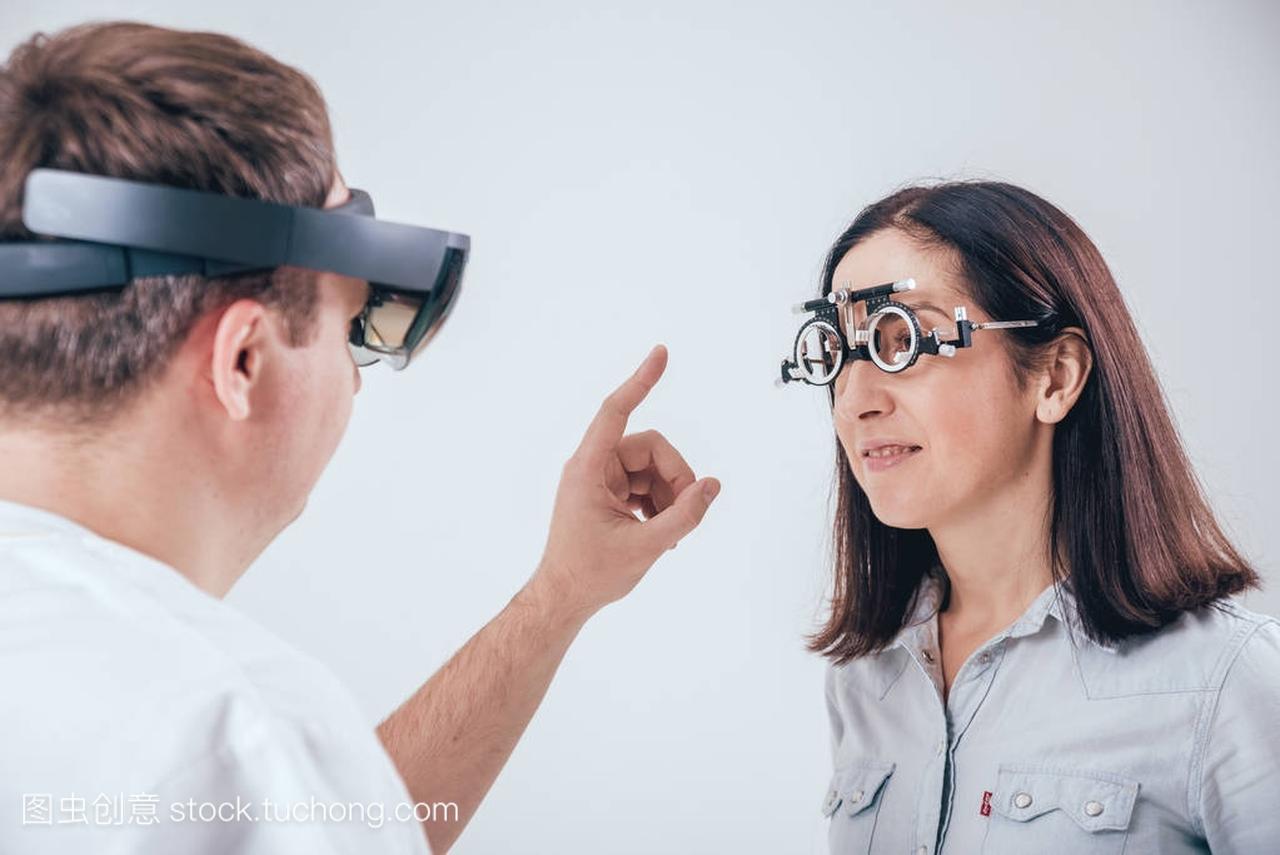 医生使用增强现实眼镜眼科咨询妇女。现代技术