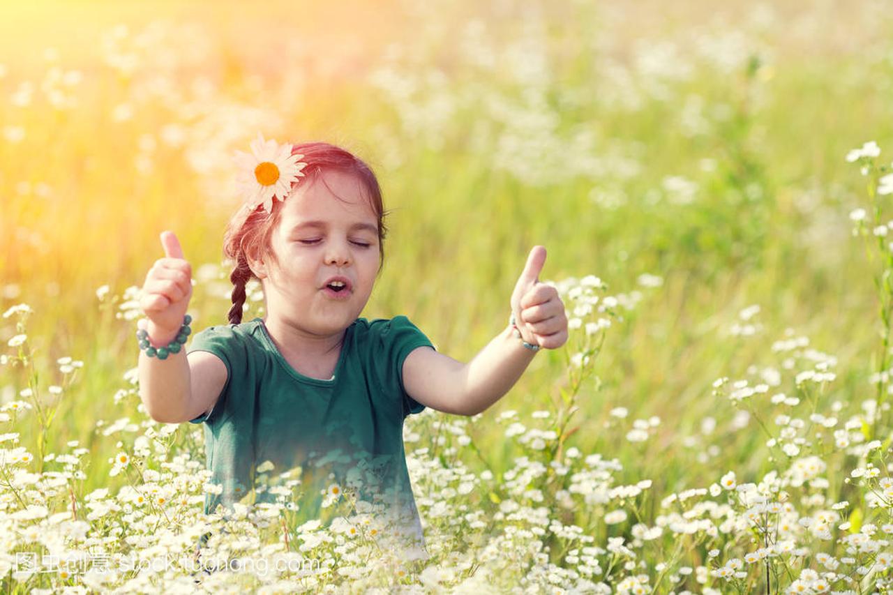愉快的唱歌小女孩与拇指在花草甸
