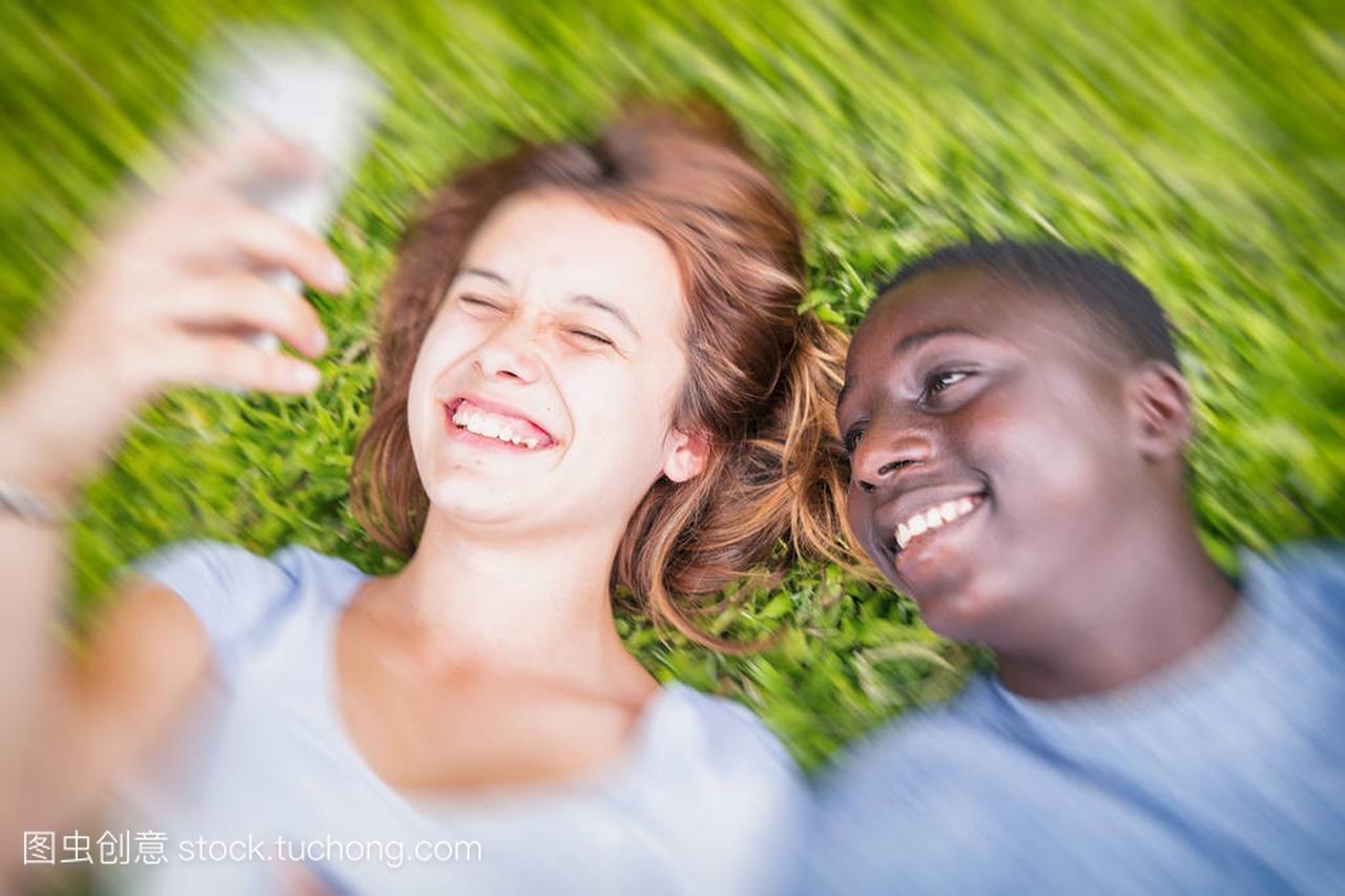 美国黑人男孩和白种女孩躺在草地上快乐 m