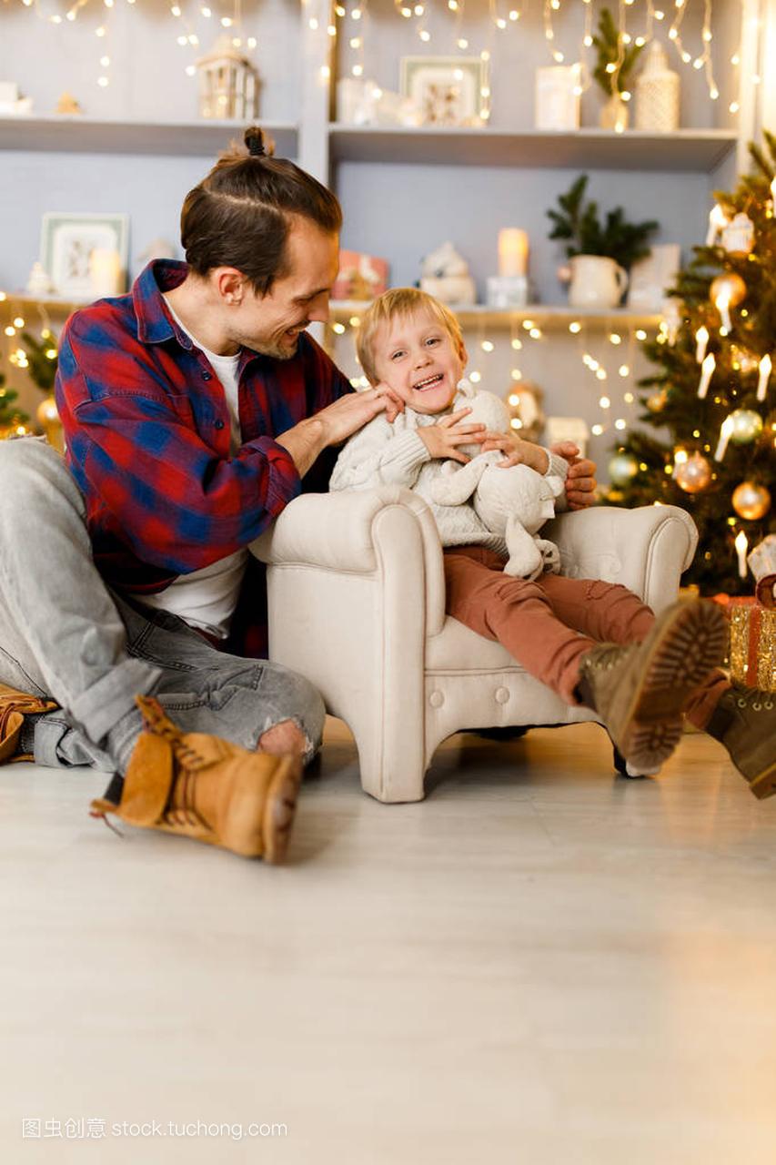 椅子上的男孩和快乐的爸爸的节日图片