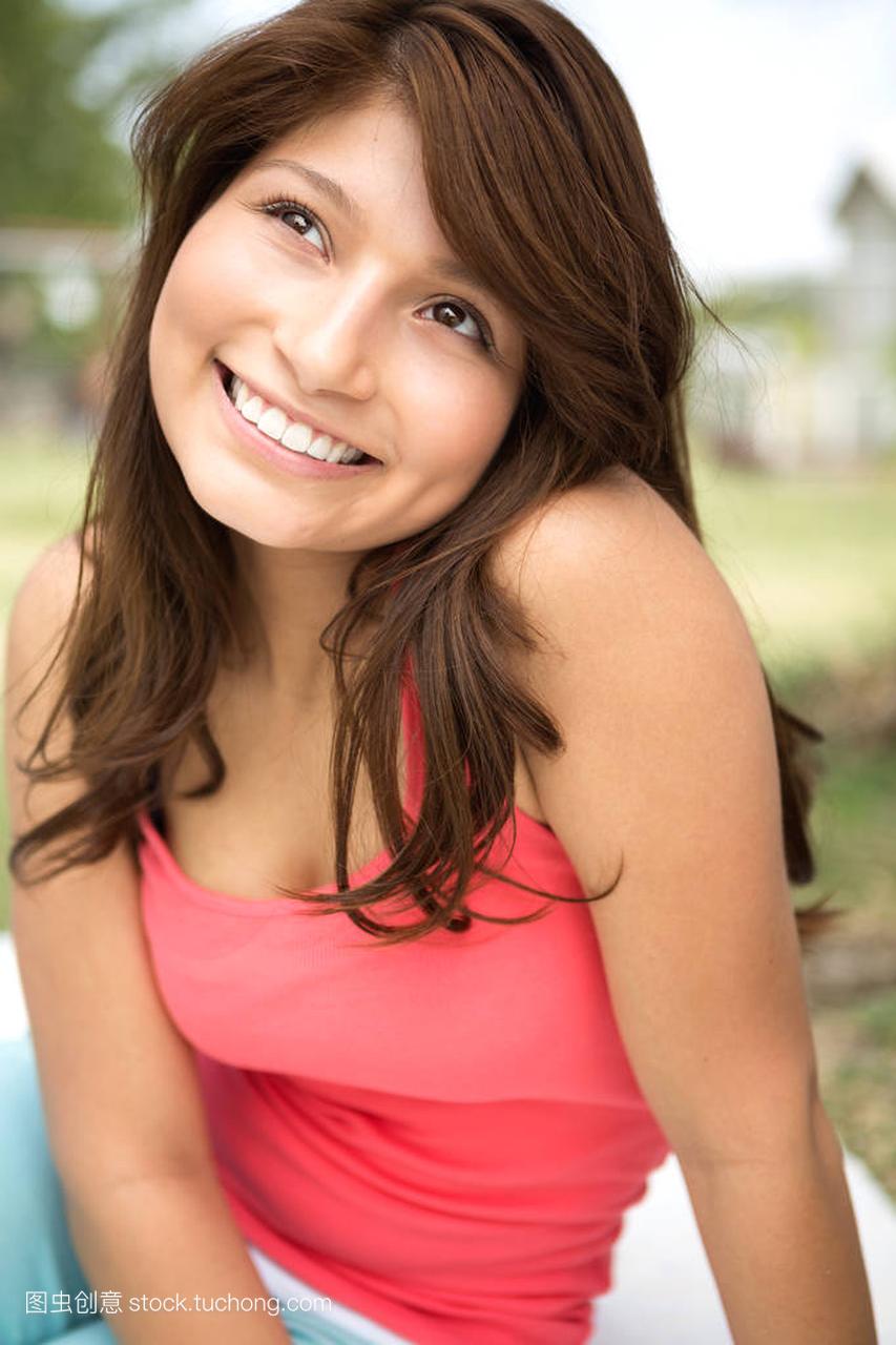 年轻的拉美裔女孩在外面微笑