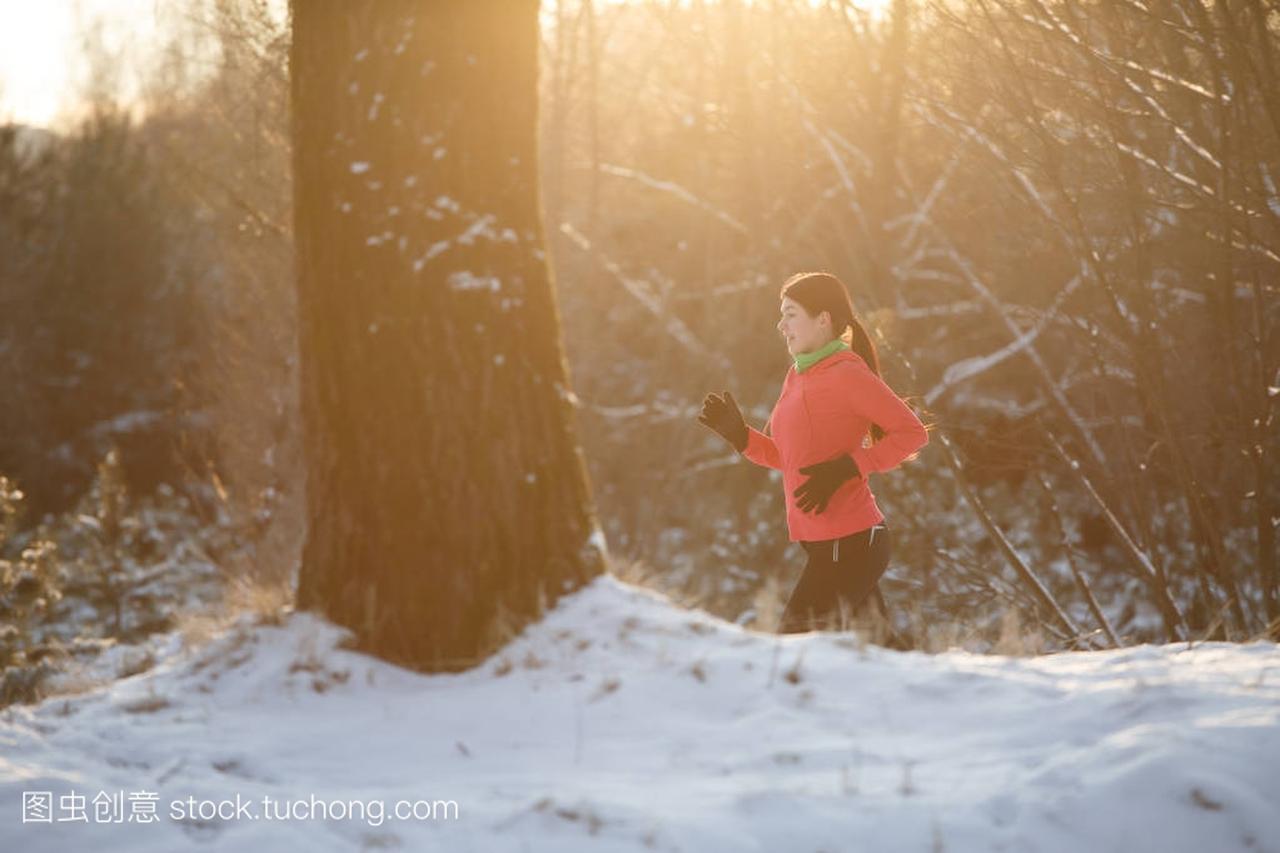 晨跑的冬季森林体育女孩照片