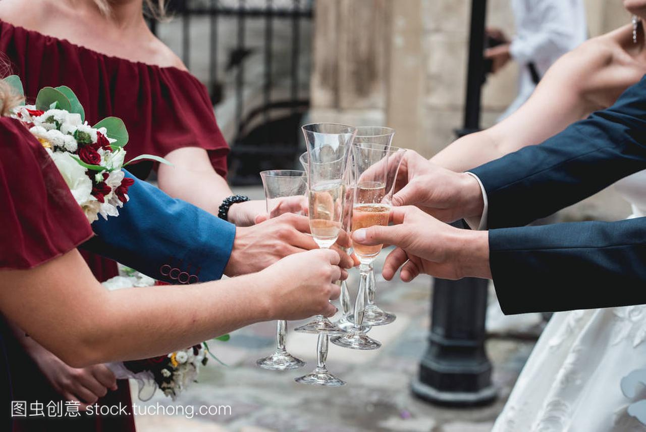 人们抱在手里的眼镜,白葡萄酒。婚宴