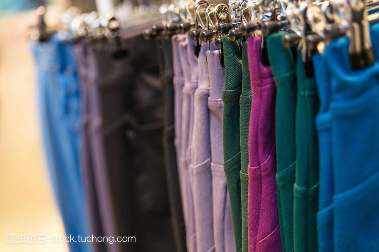 许多彩色牛仔裤挂在衣架上的服装店