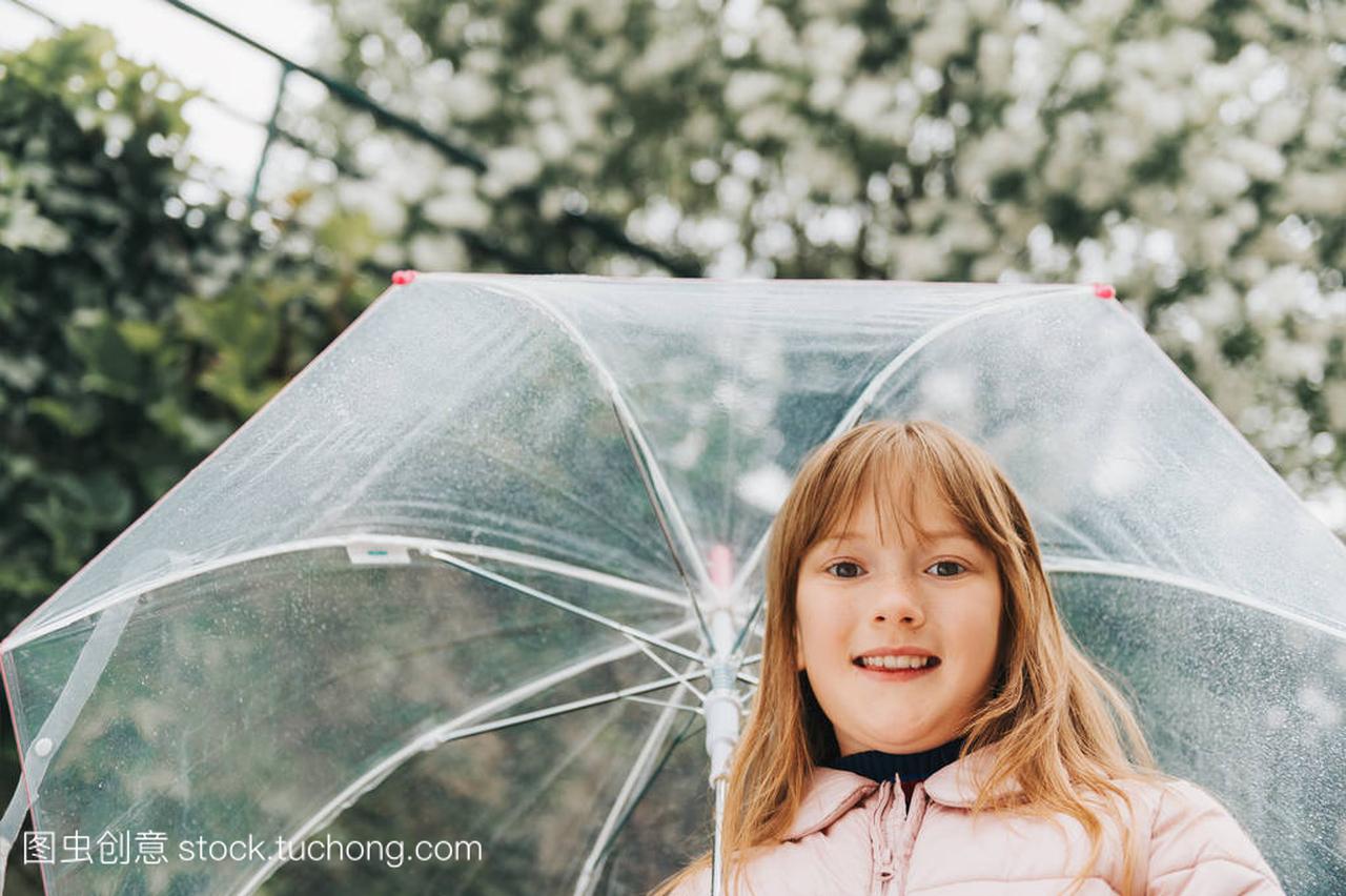 可爱的小女孩的滑稽的肖像与透明的雨伞, 春天