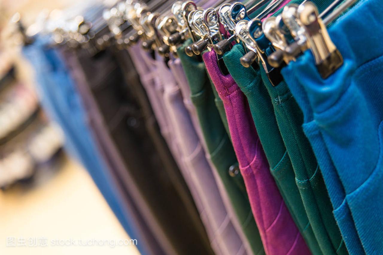 许多彩色牛仔裤挂在衣架上的服装店