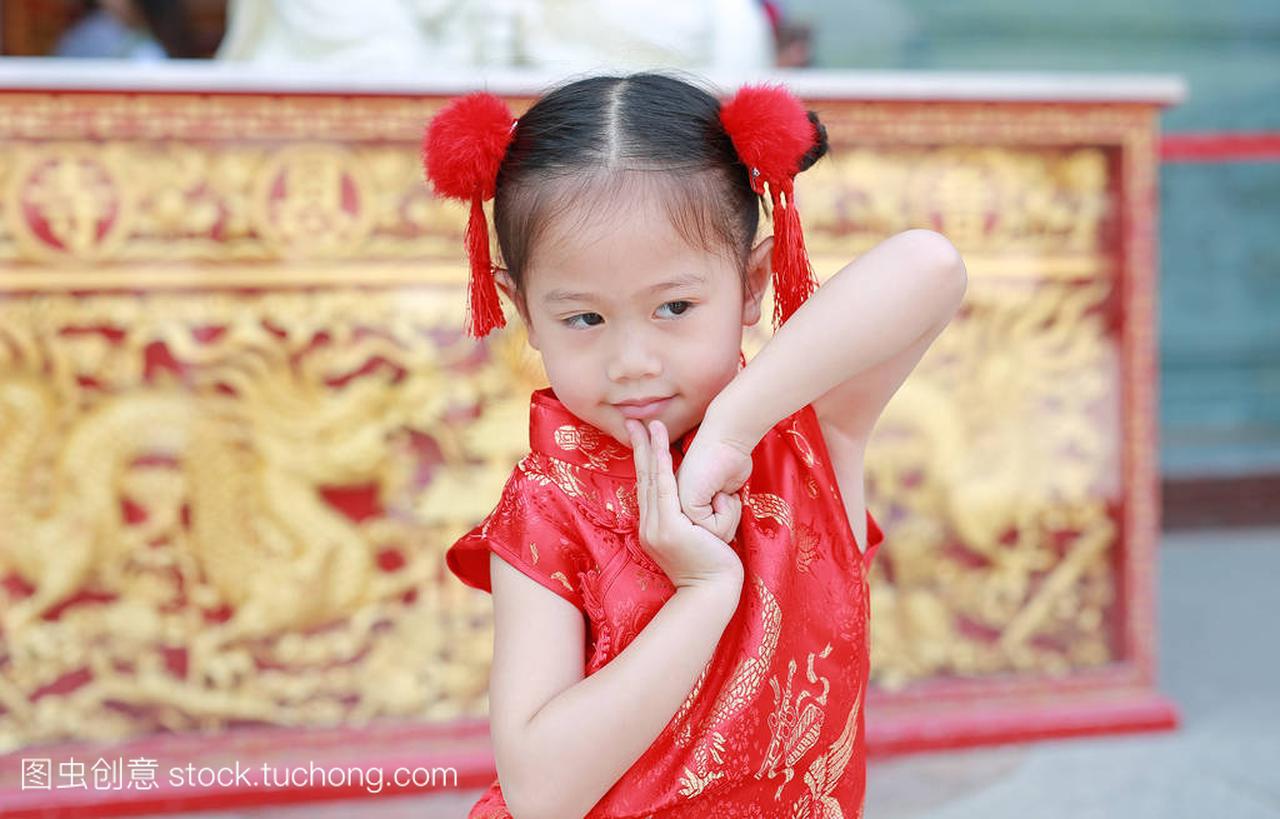 乐的小亚细亚女孩穿着红色旗袍, 在泰国华人寺