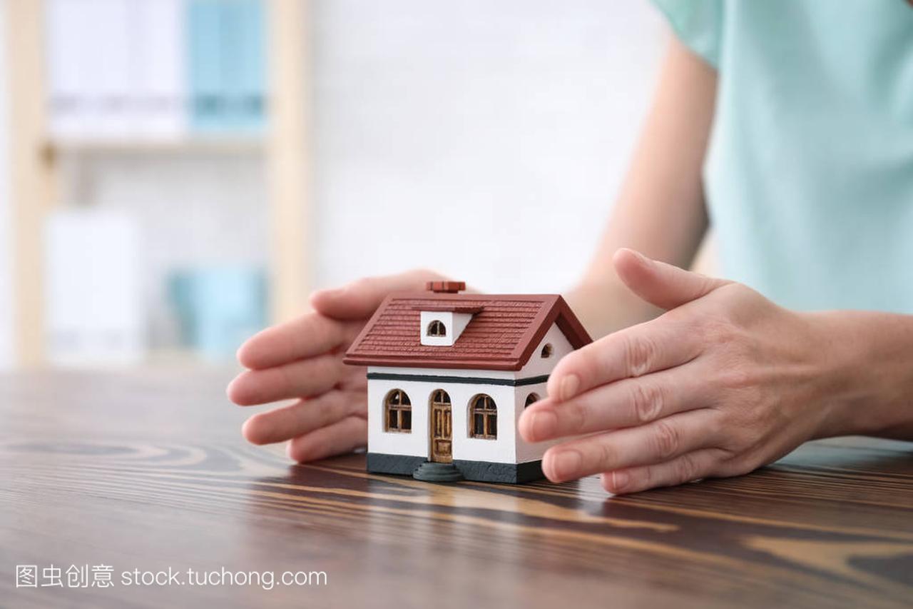 房地产经纪人与房子模型在表。保险理念