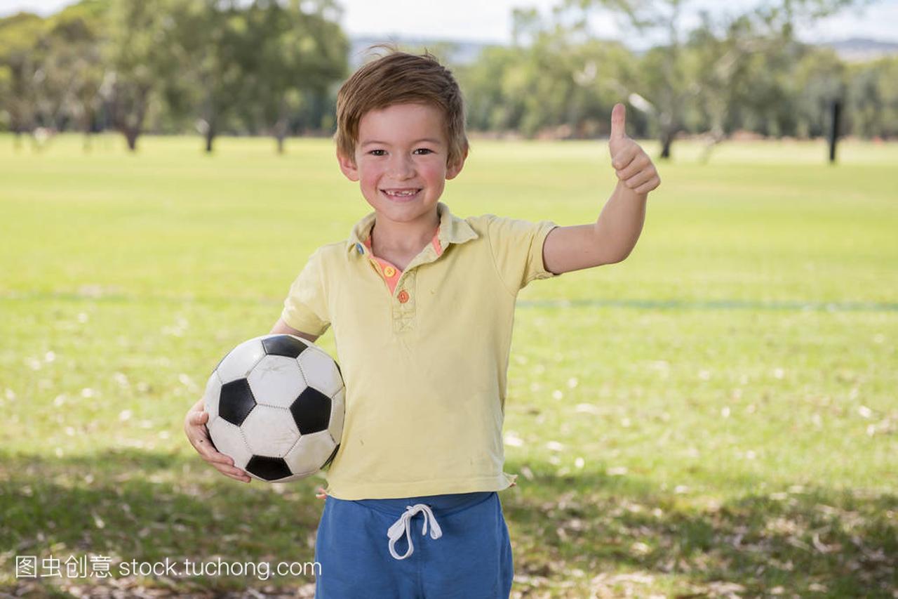 年轻的孩子7或8岁享受快乐踢足球足球在草市