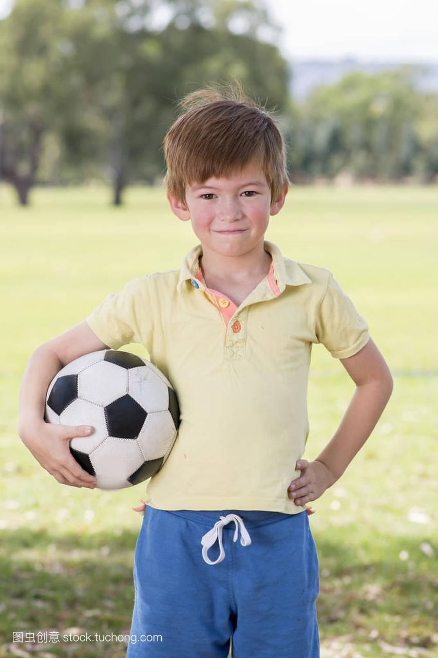 年轻的孩子7或8岁享受快乐踢足球足球在草市