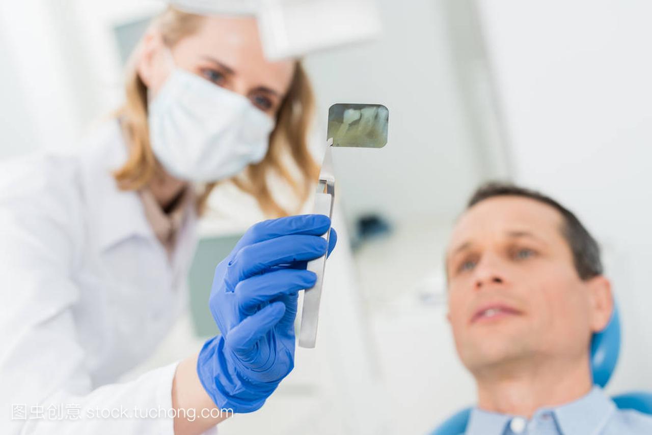 现代诊所的牙科医生看 x 光的人咨询