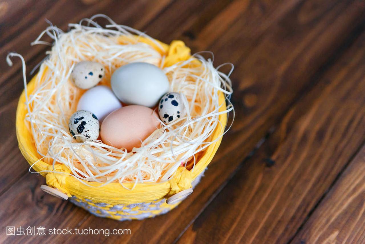 复活节彩蛋的不同颜色和鹌鹑蛋在一个柳条篮的