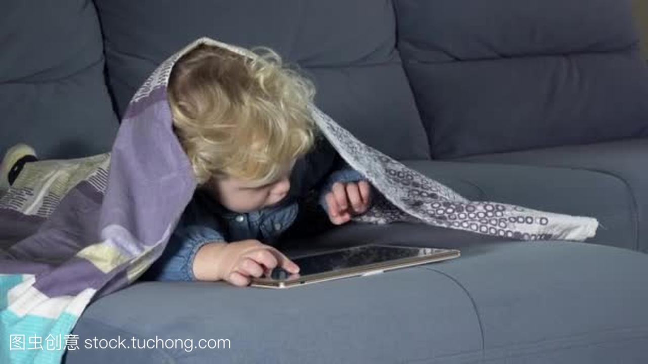 电脑成瘾儿童触摸平板电脑屏幕。披着格子的女