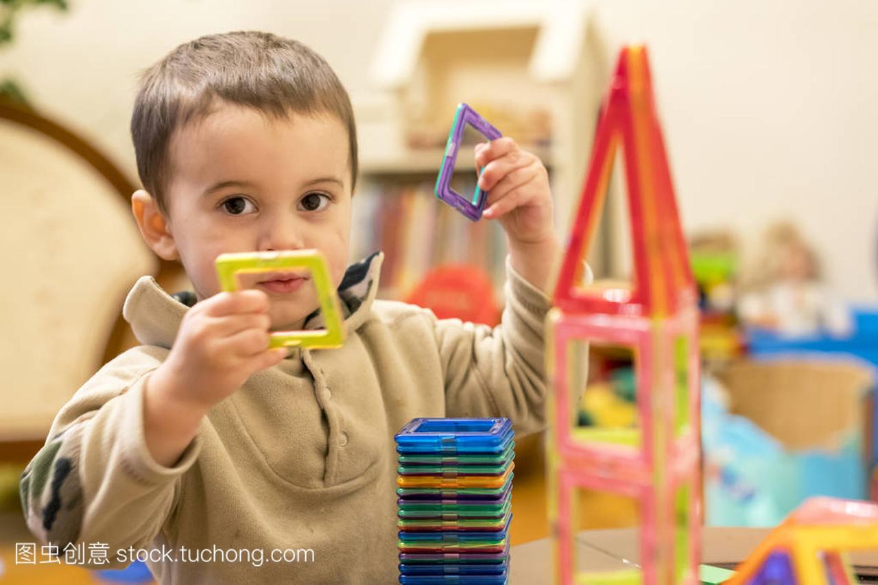 一个2岁的男孩正在玩磁性构造器。益智玩具