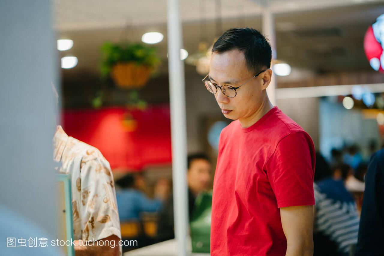 新加坡华人男子正在排队购买食品在商场的食品