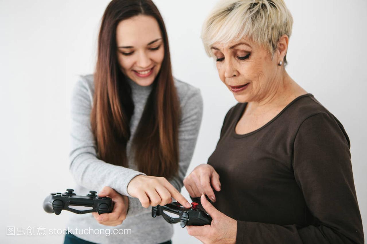 一个年轻的女孩向一位老妇人解释如何使用游戏